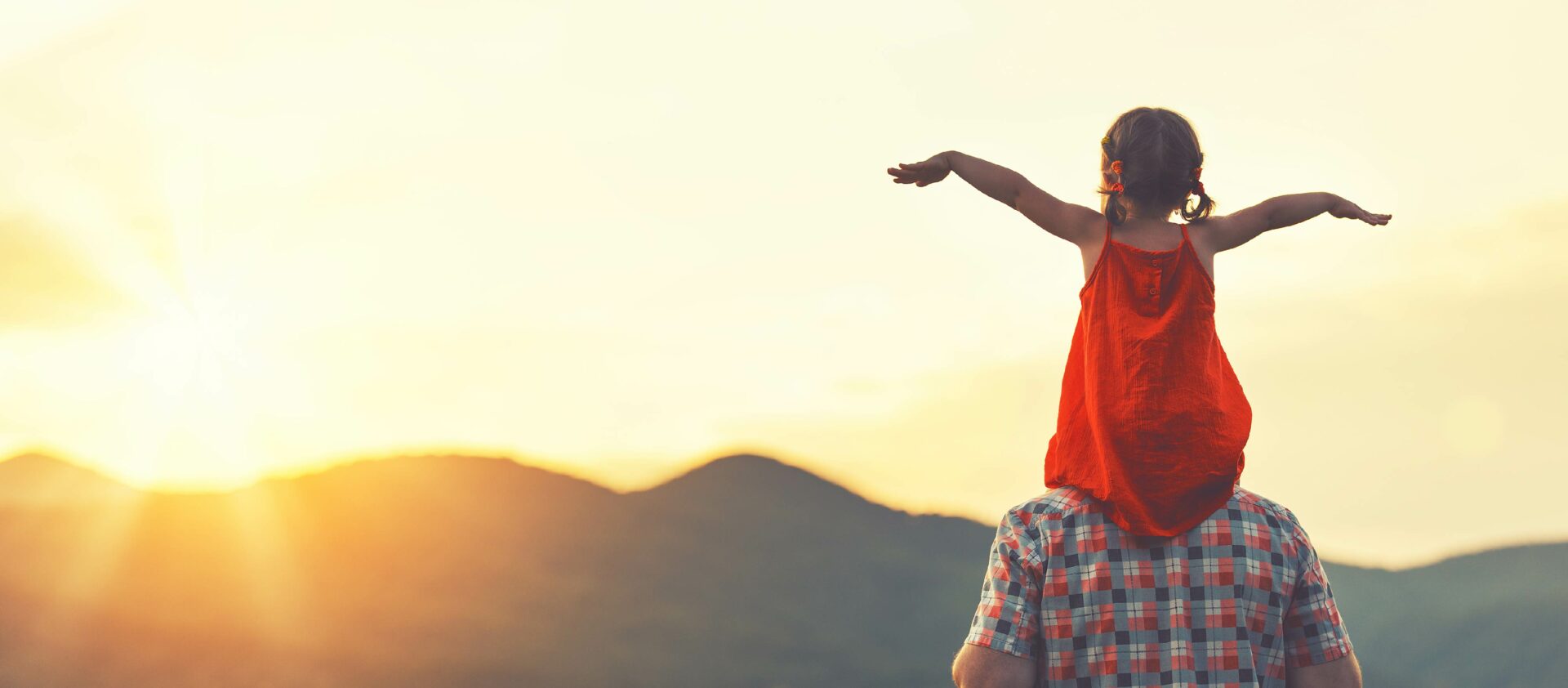 Child and parent looking at sunset